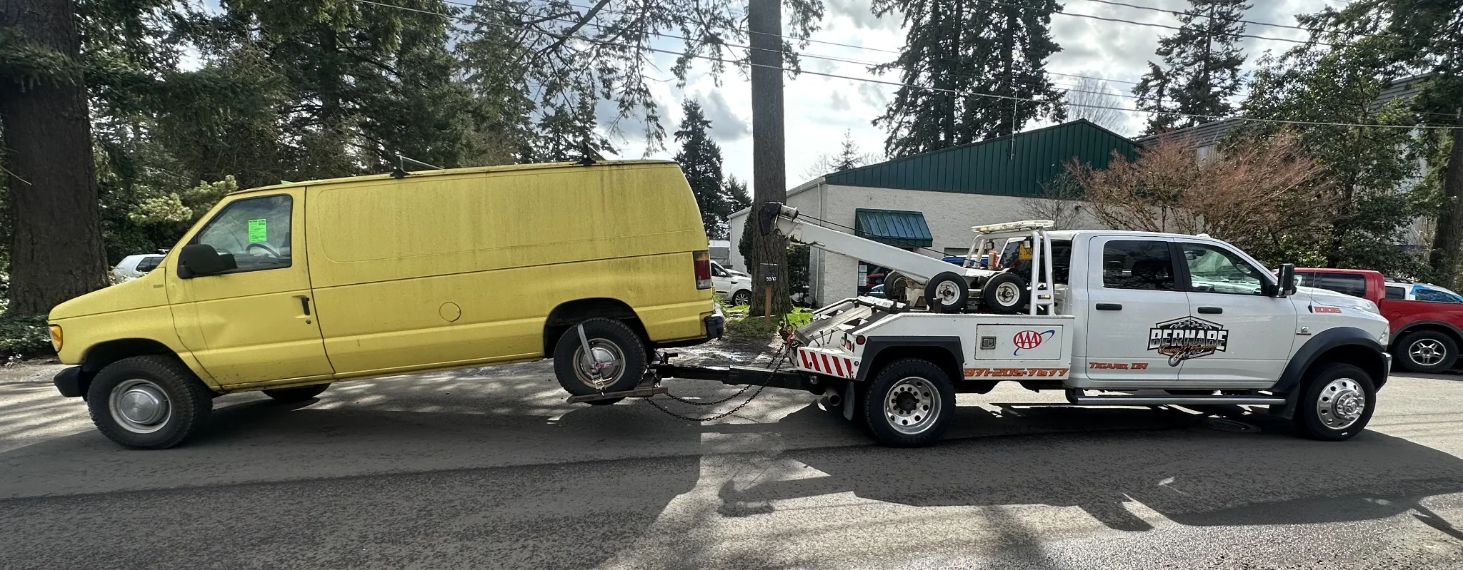 Commercial van transport with a Bernabe Towing truck.