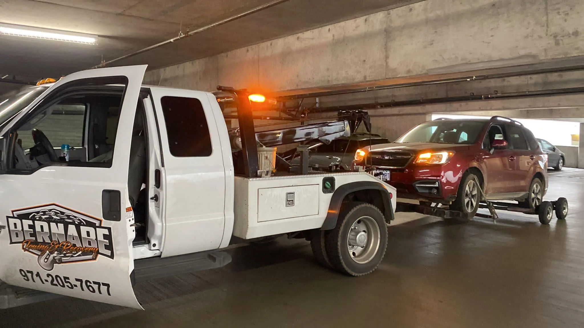 SUV being assisted by Bernabe Towing in a parking garage.